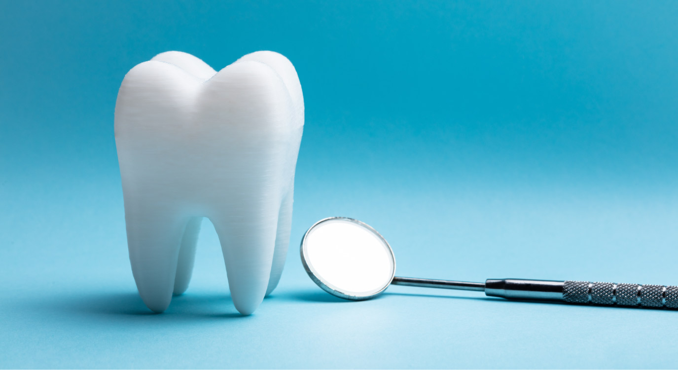 Closeup of a tooth extraction next to a special dental mirror on a blue background in Shoreline, WA