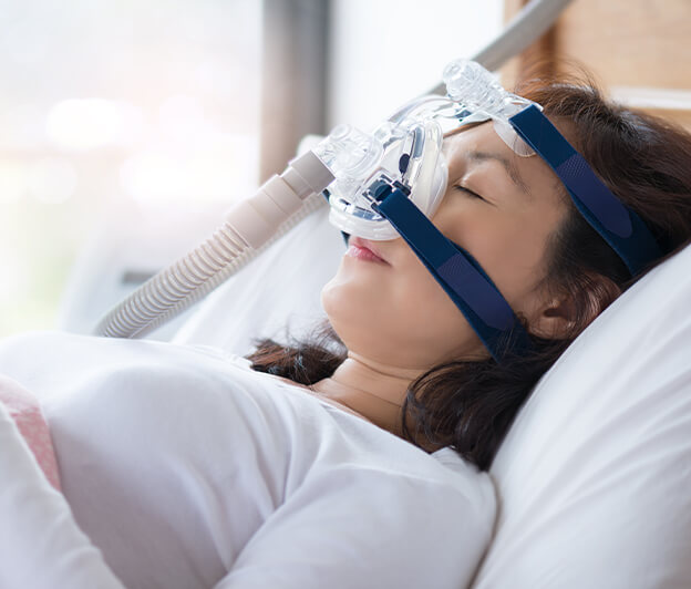 sleeping woman wearing a CPAP mask