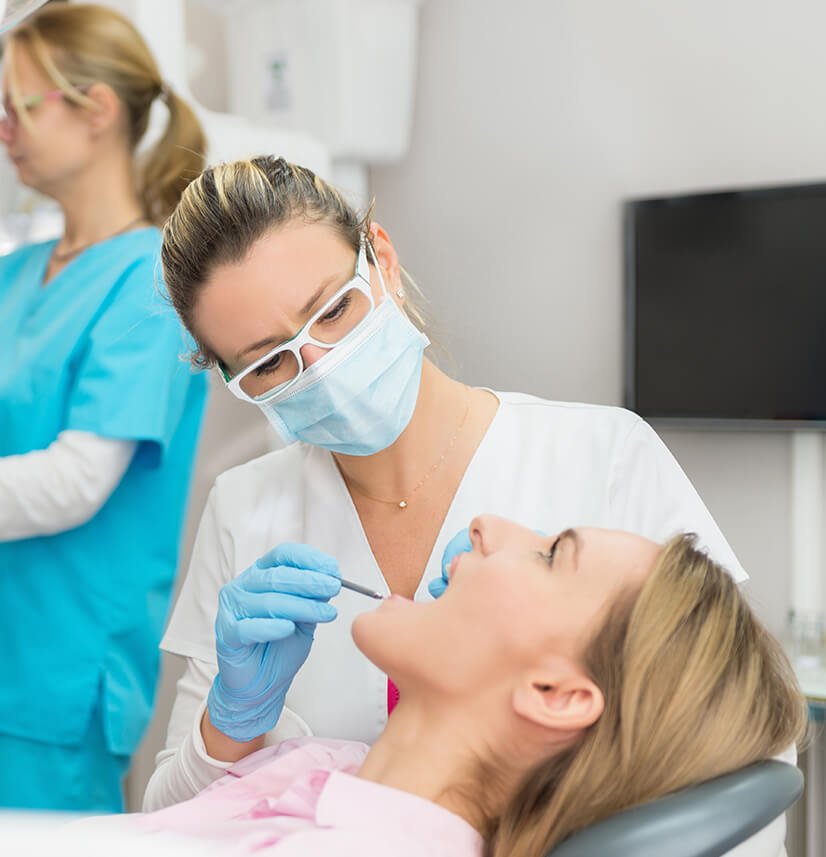 woman having her teeth examined by a dentist