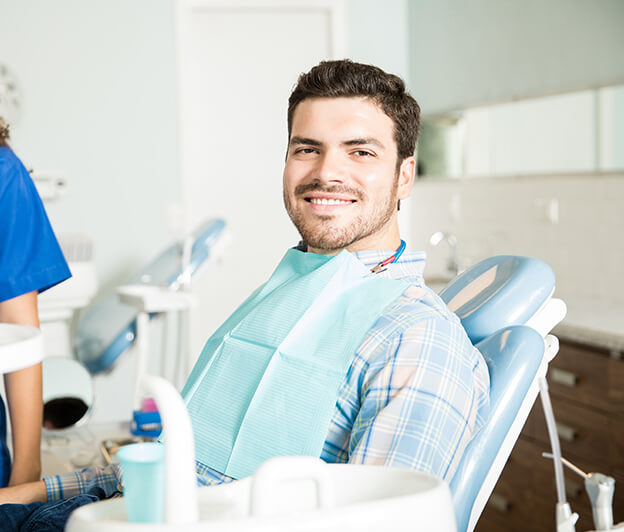 smiling man sitting in a dental chair