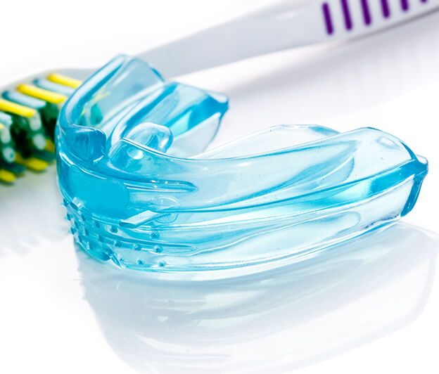mouthguard positioned next to a toothbrush