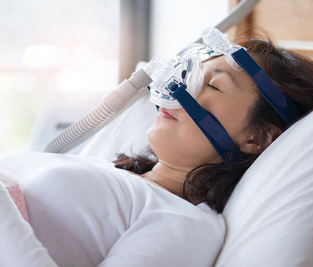 sleeping woman wearing a CPAP mask